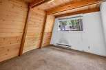 Experience rustic charm in this A-frame style room, featuring warm wood paneling on the walls and ceiling.