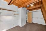 Discover ample storage solutions in this unique room, featuring multiple built-in shelves and closet rods.