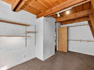 Discover ample storage solutions in this unique room, featuring multiple built-in shelves and closet rods.