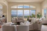 Experience breathtaking panoramic views from this stunning living room, featuring a large sectional sofa and comfortable armchairs perfect for relaxation.