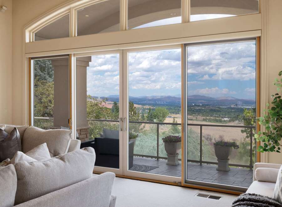 Experience breathtaking panoramic views from this stunning living room, featuring expansive sliding glass doors that open to a scenic vista.