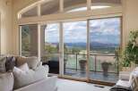 Experience breathtaking panoramic views from this stunning living room, featuring expansive sliding glass doors that open to a scenic vista.