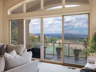 Experience breathtaking panoramic views from this stunning living room, featuring expansive sliding glass doors that open to a scenic vista.