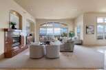 Experience breathtaking panoramic views from this stunning living room, featuring a grand marble fireplace and expansive windows that flood the space with natural light.