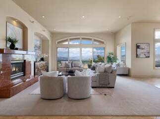 Experience breathtaking panoramic views from this stunning living room, featuring a grand marble fireplace and expansive windows that flood the space with natural light.