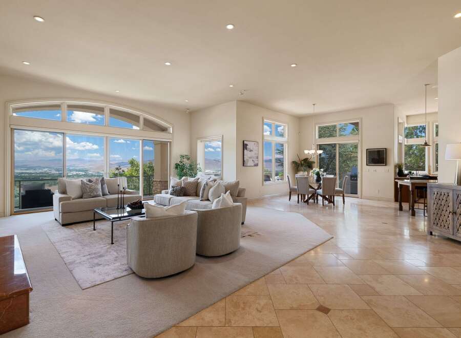 Experience breathtaking panoramic views from this expansive living area, featuring a large sectional sofa and two accent chairs perfect for entertaining.