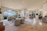 Experience breathtaking panoramic views from this expansive living area, featuring a large sectional sofa and two accent chairs perfect for entertaining.