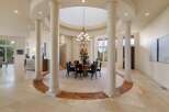 Experience elegant dining in this spacious room, featuring a grand circular dining table with seating for eight, illuminated by a stunning chandelier.