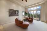 Experience breathtaking views from this stunning living room, featuring a unique curved sofa and a modern metal wall art.