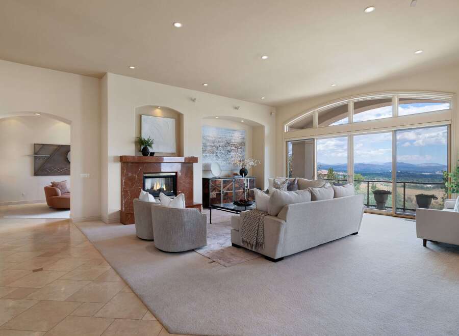 Experience luxurious living in this spacious great room, featuring a stunning marble fireplace and expansive windows that showcase breathtaking panoramic views.