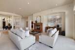 Step into this luxurious living room, featuring plush white sofas and a striking marble fireplace.