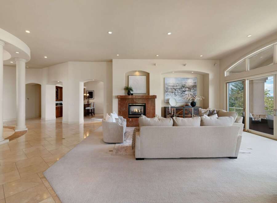 Experience luxurious living in this spacious great room, featuring a stunning marble fireplace and elegant architectural columns.