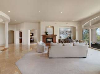 Experience luxurious living in this spacious great room, featuring a stunning marble fireplace and elegant architectural columns.