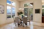Experience breathtaking panoramic views from this elegant dining room, featuring a glass-top dining table with upholstered chairs.