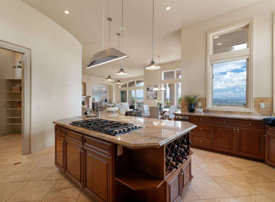 Experience luxury in this stunning kitchen, featuring a spacious island with a gas range and wine storage.