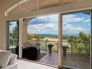 Experience breathtaking panoramic views from this stunning property, featuring expansive sliding glass doors that seamlessly blend indoor and outdoor living.