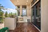 Experience outdoor living at its finest with this well-appointed patio kitchen, featuring a built-in stainless steel grill and a convenient sink area.