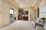 This spacious room features a built-in wet bar with rich wood cabinetry, a microwave, and a mini-fridge, perfect for entertaining.