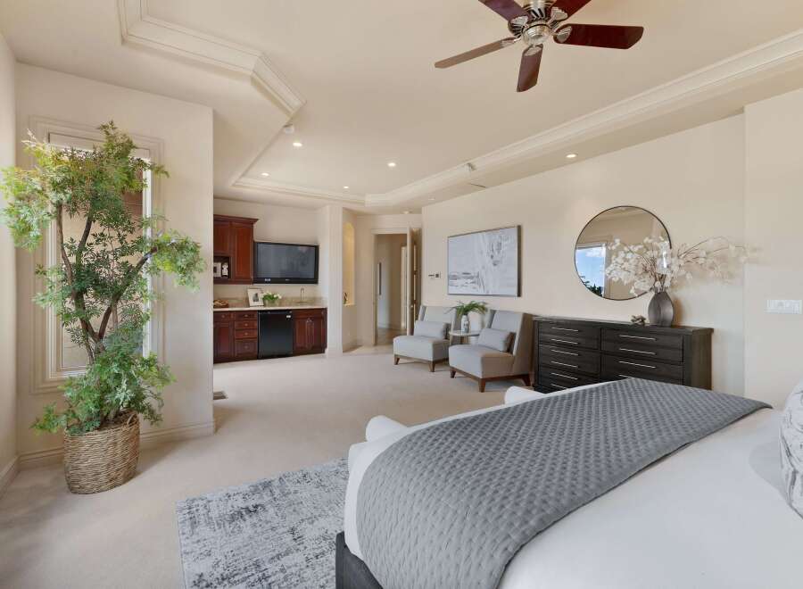 Experience luxury in this spacious master suite, featuring a private wet bar with a mini-fridge and microwave, perfect for in-room refreshments.