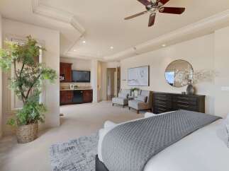 Experience luxury in this spacious master suite, featuring a private wet bar with a mini-fridge and microwave, perfect for in-room refreshments.