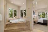 Indulge in luxury with this spacious master suite featuring a spa-like bathroom with a large soaking tub and stunning nature views.