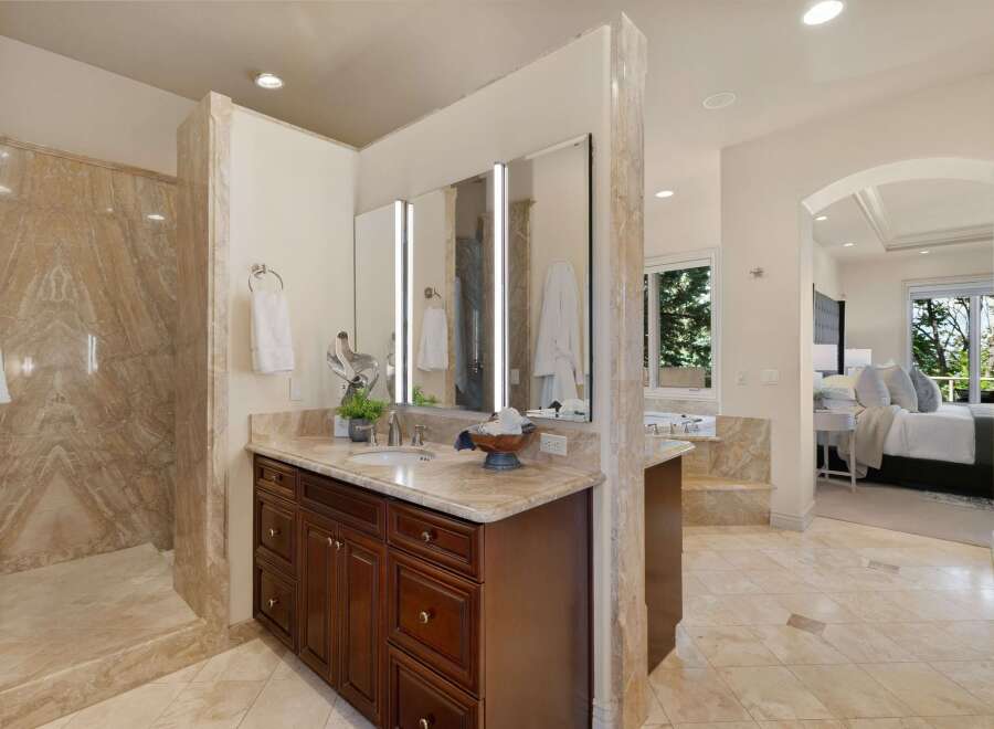 Experience luxury in this master bathroom featuring a spacious marble shower and a double vanity with ample storage.