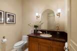 This elegant bathroom features a sleek white toilet and a stylish vanity with a dark granite countertop.