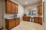 This spacious laundry room features beautiful custom wood cabinetry, providing ample storage for all your laundry needs.