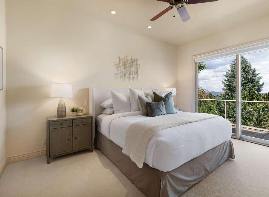 Experience luxurious comfort in this master bedroom, featuring a plush king-sized bed adorned with crisp white linens and accent pillows.