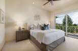 Experience luxurious comfort in this master bedroom, featuring a plush king-sized bed adorned with crisp white linens and accent pillows.