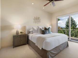 Experience luxurious comfort in this master bedroom, featuring a plush king-sized bed adorned with crisp white linens and accent pillows.