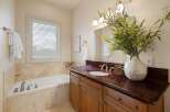 Indulge in relaxation in this elegant bathroom, featuring a spacious soaking tub perfect for unwinding after a long day.