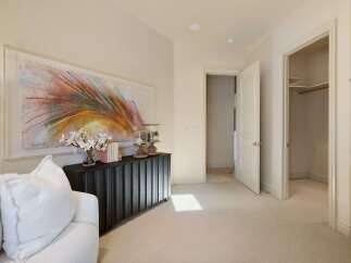 This inviting space features a striking abstract artwork above a dark fluted console table, complemented by a plush white sofa.