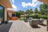 Enjoy outdoor living with this spacious patio featuring a luxurious hot tub and comfortable wicker seating.