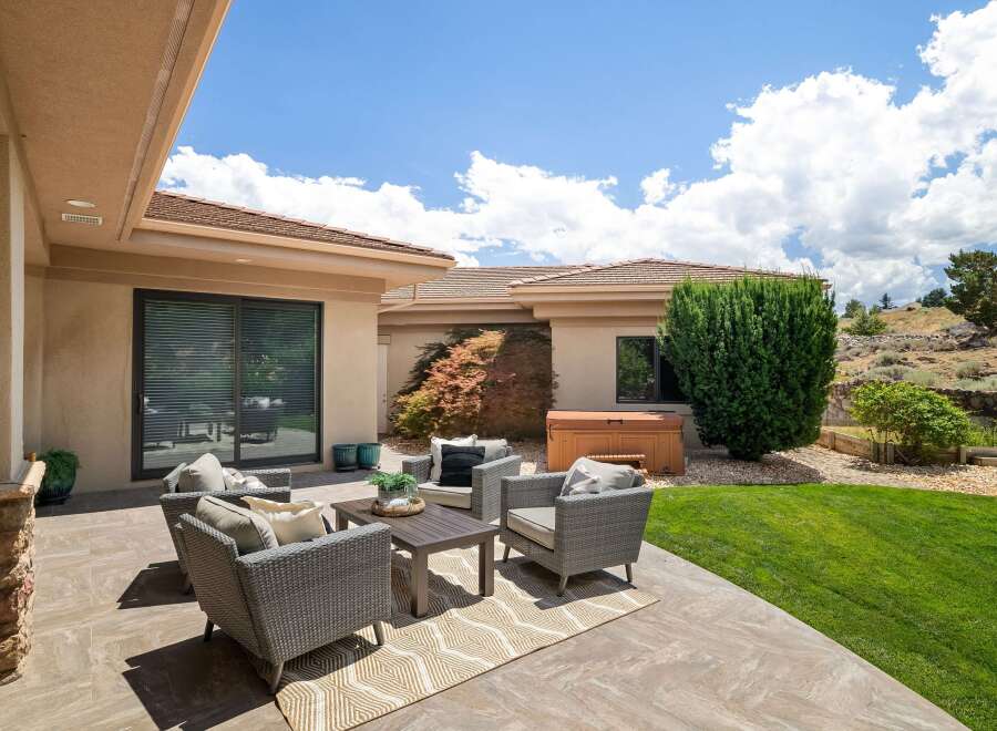 Enjoy outdoor living with this spacious patio featuring comfortable wicker seating and a coffee table, perfect for entertaining.