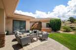 Enjoy outdoor living with this spacious patio featuring comfortable wicker seating and a coffee table, perfect for entertaining.