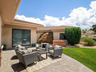 Enjoy outdoor living with this spacious patio featuring comfortable wicker seating and a coffee table, perfect for entertaining.