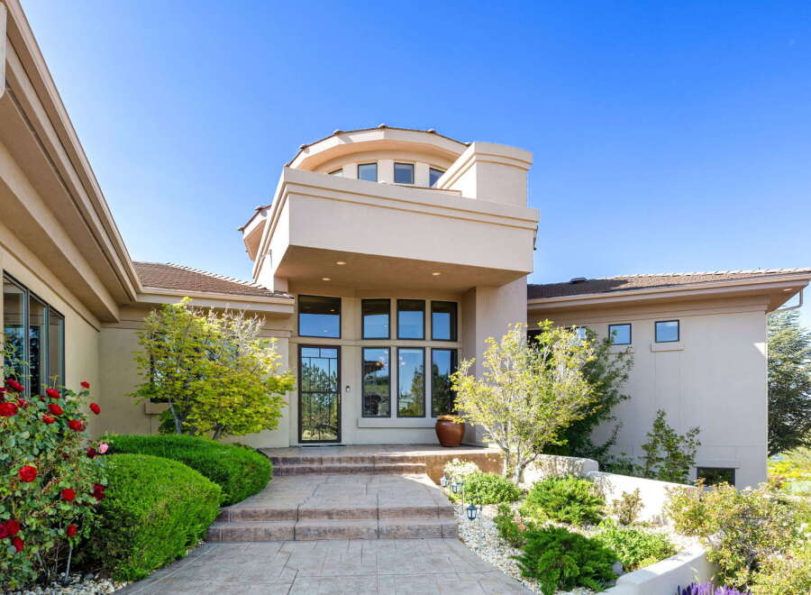 Welcome to this stunning home featuring a grand entrance with a multi-level facade and a prominent circular turret.