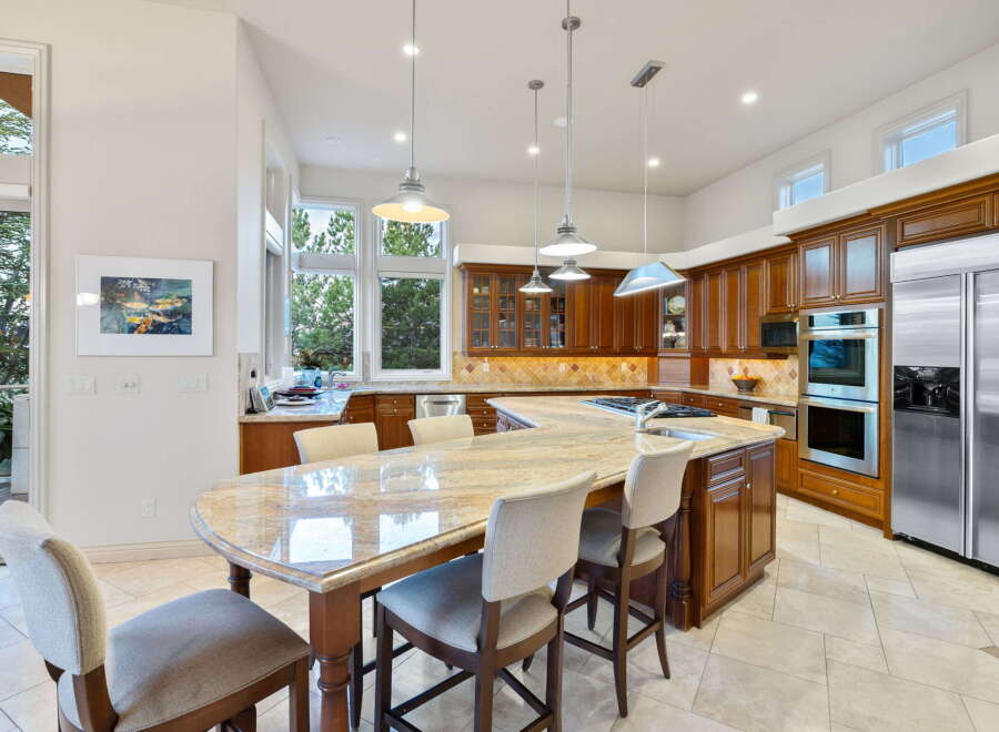 This spacious kitchen boasts custom cherry wood cabinetry and a large granite island, perfect for entertaining.
