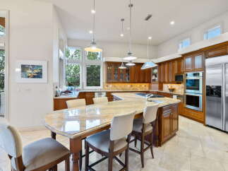 This spacious kitchen boasts custom cherry wood cabinetry and a large granite island, perfect for entertaining.