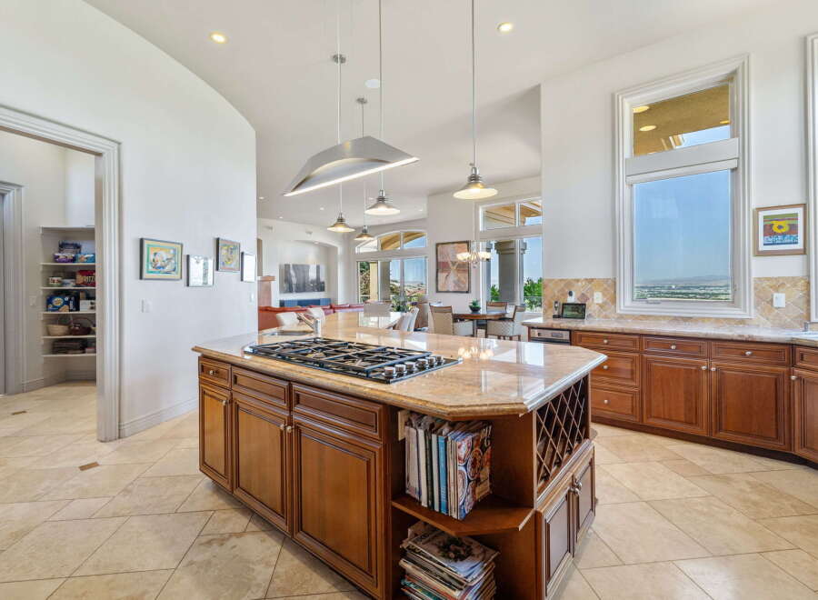 Experience luxury in this spacious kitchen, featuring a central island with a gas stovetop and granite countertops.