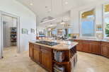 Experience luxury in this spacious kitchen, featuring a central island with a gas stovetop and granite countertops.