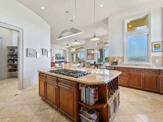 Experience luxury in this spacious kitchen, featuring a central island with a gas stovetop and granite countertops.