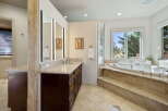 Indulge in luxury with this stunning master bathroom featuring a spacious soaking tub and a large vanity with ample counter space.