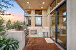 Experience outdoor living at its finest with this modern patio featuring a built-in stainless steel grill and a convenient sink area.