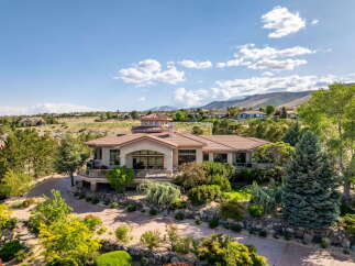 Experience luxury living in this stunning estate, featuring a grand circular turret and expansive windows that capture breathtaking mountain views.