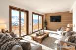 Experience breathtaking mountain views from this luxurious living room, featuring floor-to-ceiling windows that open onto a private balcony.