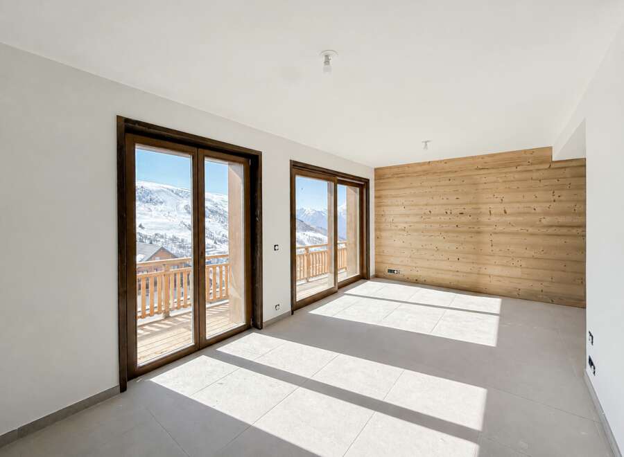 Experience breathtaking mountain views from this spacious room featuring large sliding glass doors that open onto a private balcony.