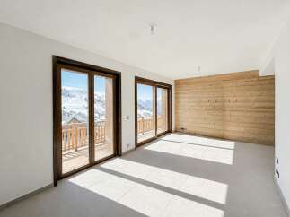 Experience breathtaking mountain views from this spacious room featuring large sliding glass doors that open onto a private balcony.