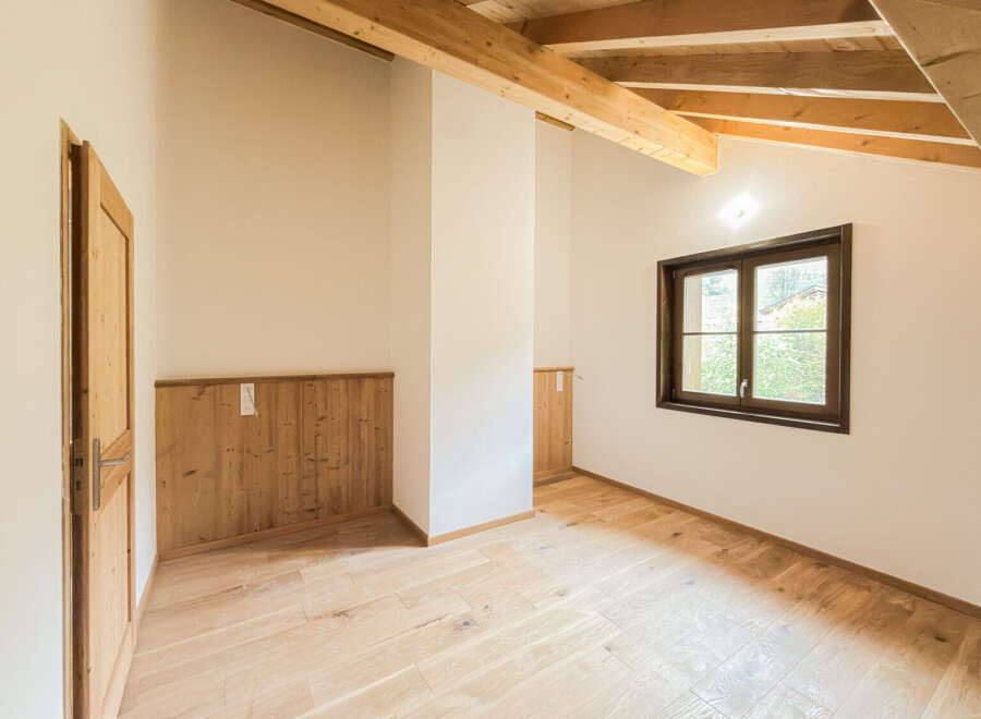 Experience rustic charm in this beautifully appointed room featuring exposed wooden beams and warm, natural wood paneling.